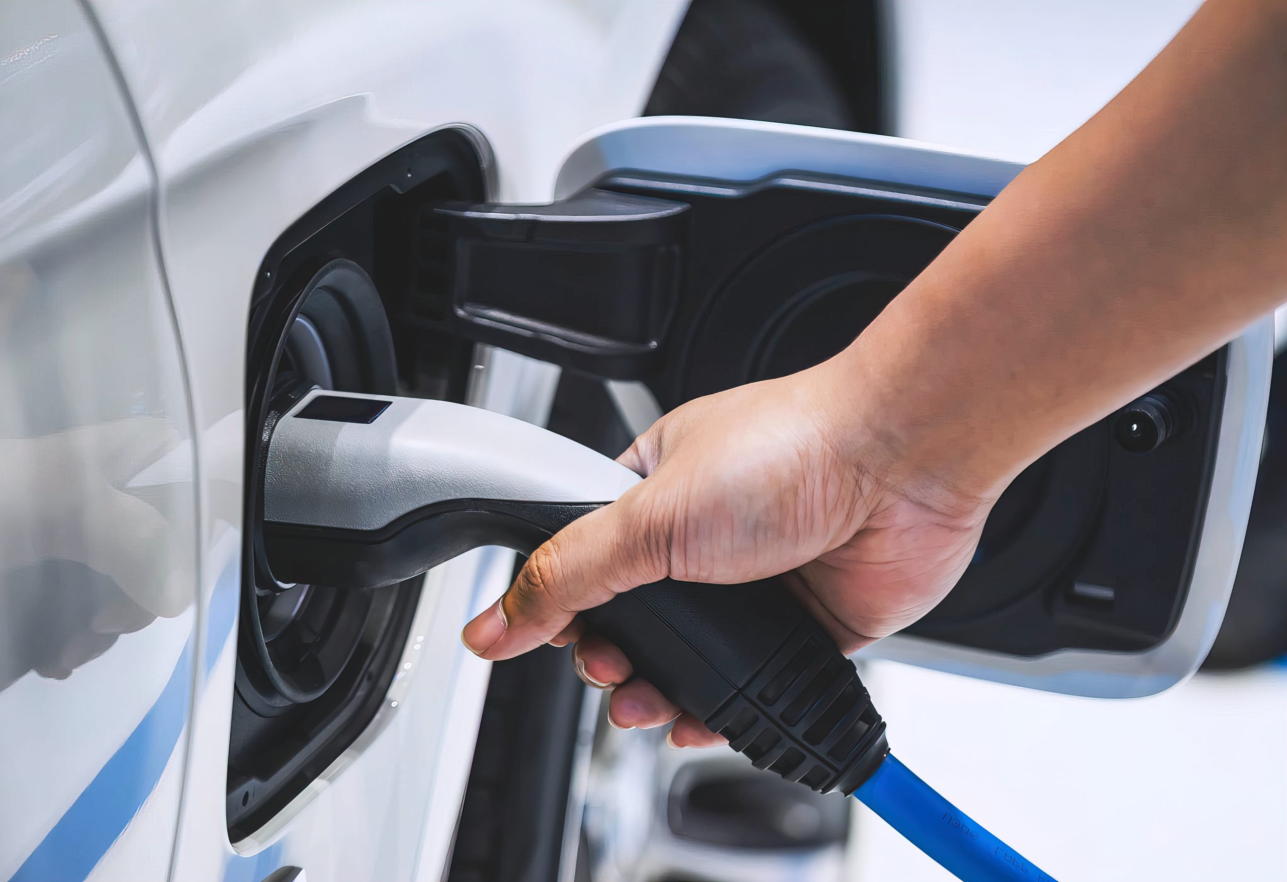 An electric vehicle charger being plugged into an electric vehicle